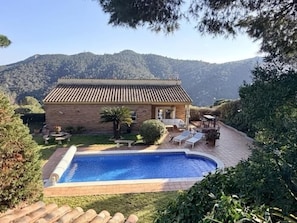 A stone building with a tiled roof, a swimming pool, and outdoor seating. - Calma Mar by Costabravaway (Sant Feliu de Guíxols)