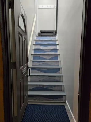 Un escalier dont les marches sont décorées de motifs, menant à un palier.