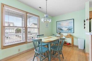 A dining area with a table, chairs, and a chandelier. - "Pirate Pride" a Charming 3 Bedroom, 2 Bathroom, Dunes Home! (Holden Beach)