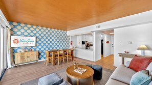 Ein modernes Wohnzimmer mit Essbereich, einer Küche und einem Flur.