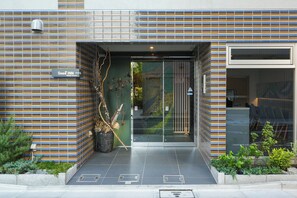 A modern building entrance with a striped facade, a sign for 'Seed Inn,' and a glass door leading inside. - Seed INN Haneda Terrace (Tokyo)