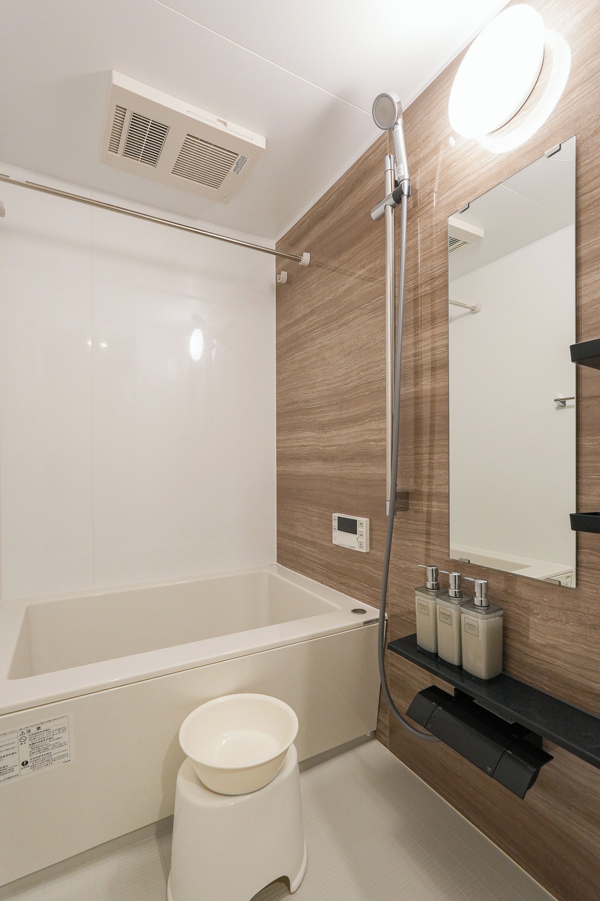A modern bathroom with a bathtub, a toilet, a sink, and a mirror.