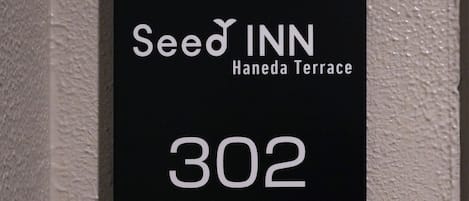 A black sign with white text indicating 'Seed Inn Haneda Terrace 302'.