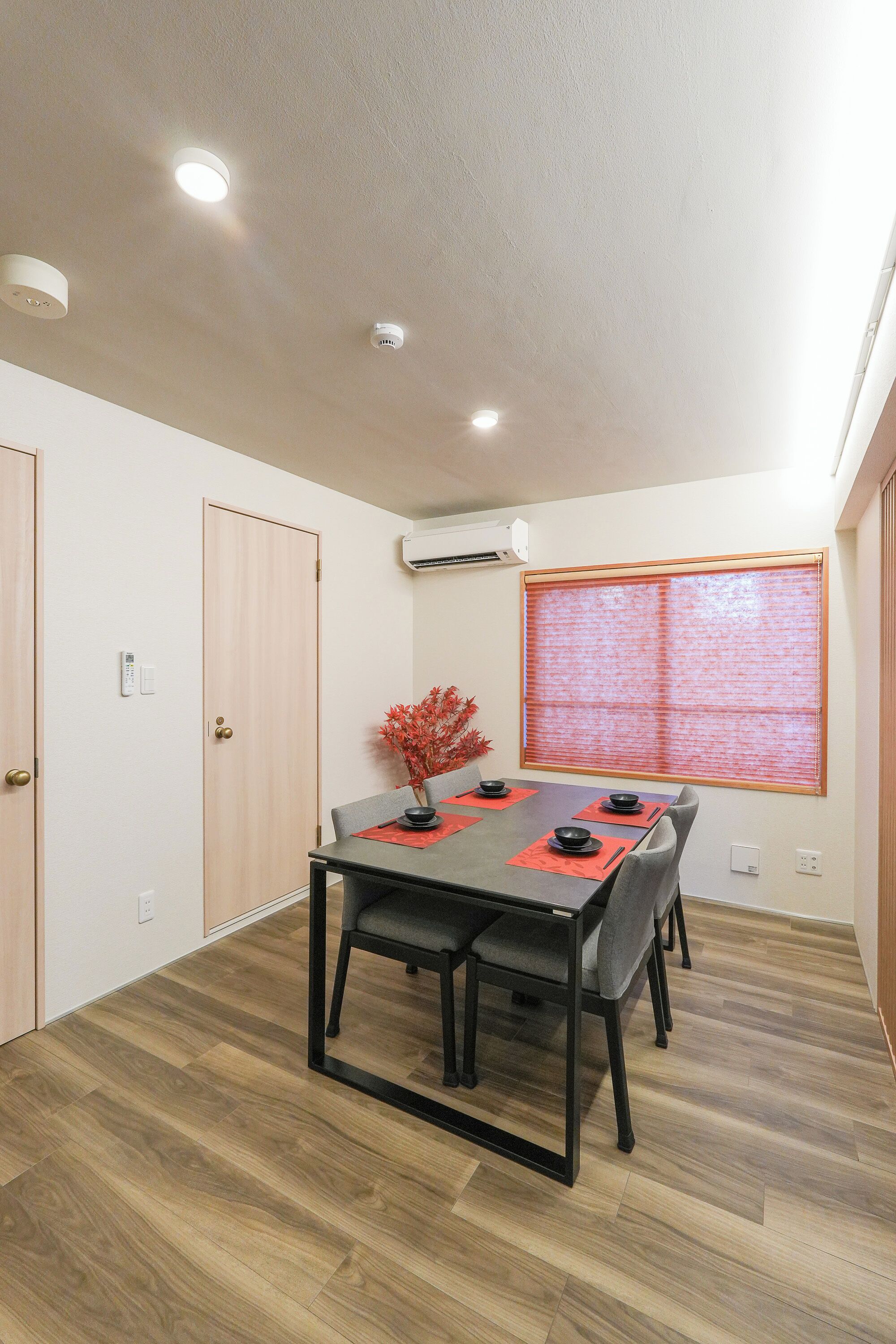 Un comedor con una mesa, sillas y una ventana con persianas.