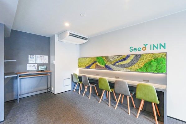 A modern office space with a reception desk, a large wall-mounted display, and several chairs. - Seed INN Haneda Terrace (Tokyo)