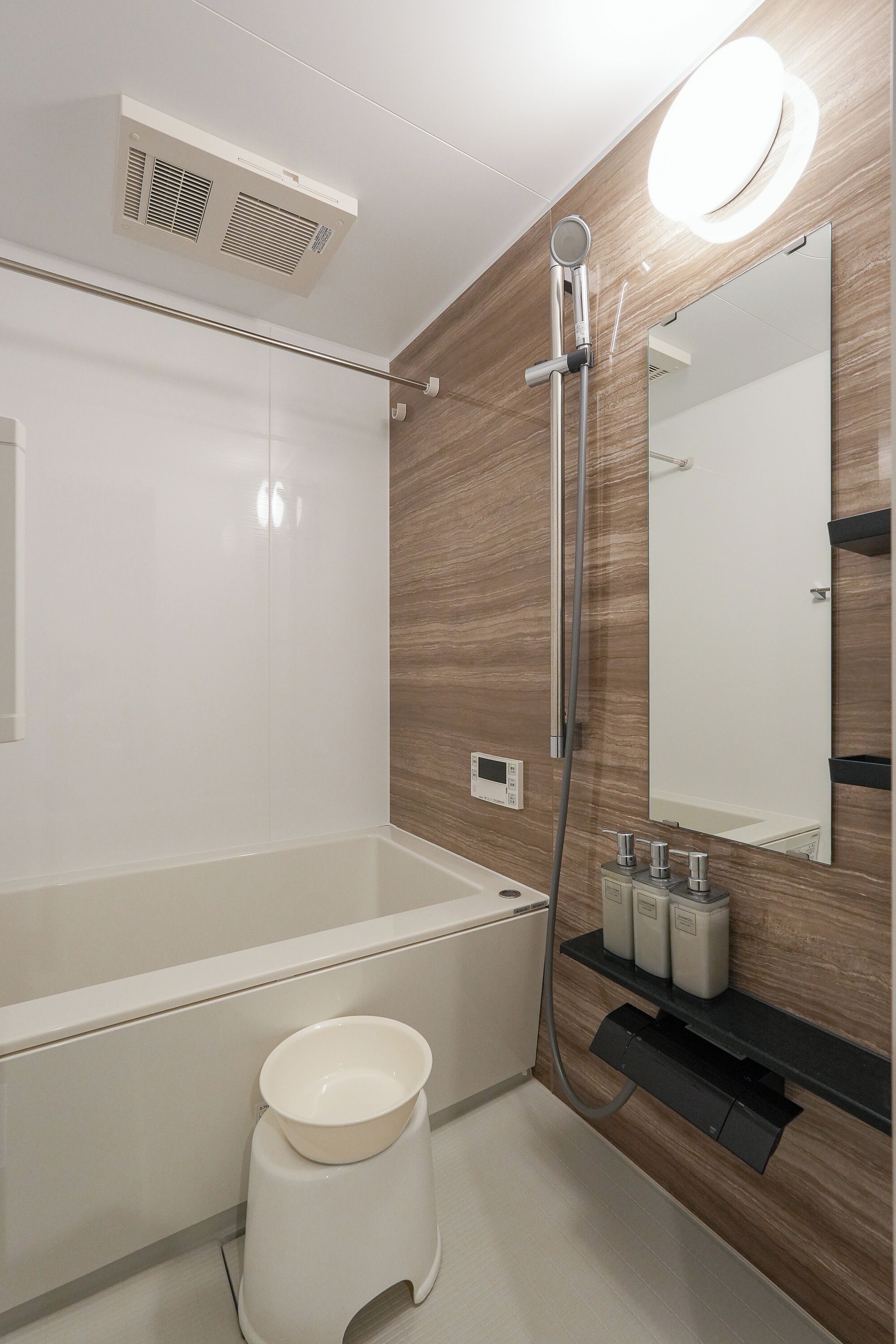 A modern bathroom with a bathtub, a toilet, a sink, a mirror, and a shower.