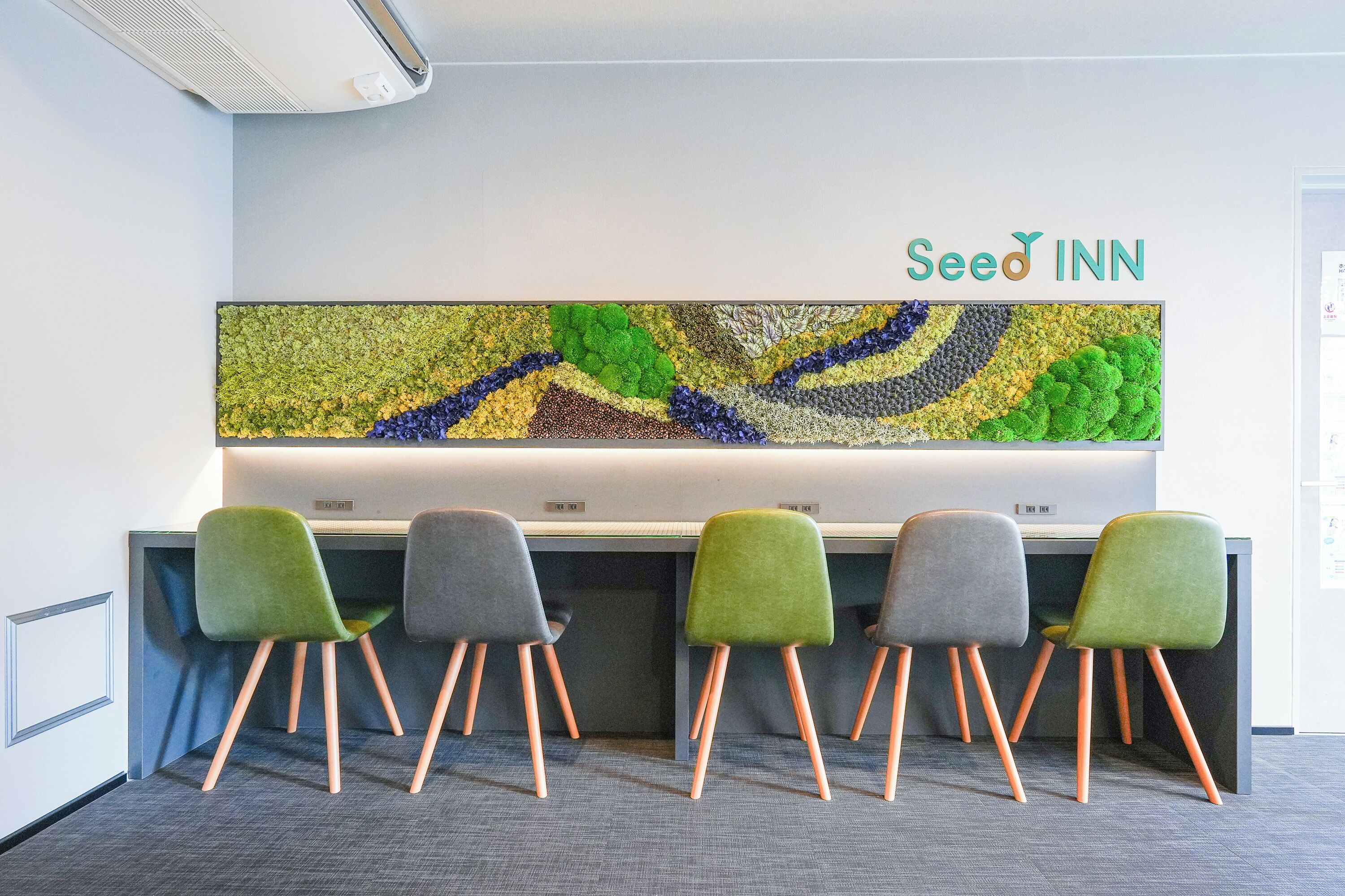 Een vergaderzaal met een lange tafel, vier stoelen en een kunstwerk aan de muur.