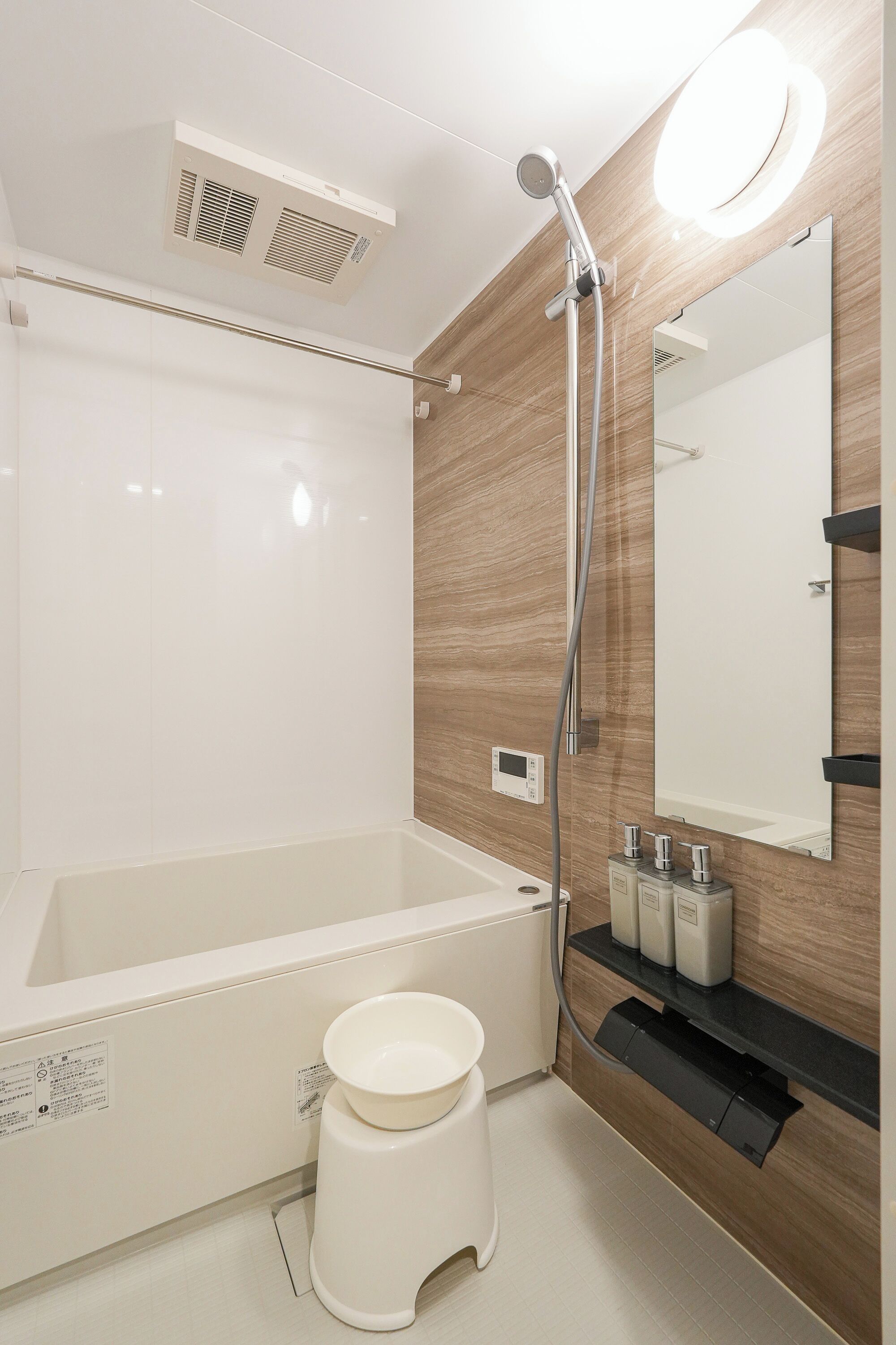 A modern bathroom with a bathtub, a toilet, a shower, and a mirror.