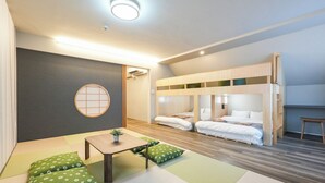 A room with tatami mats, a low wooden table, two green cushions, a futon bed, and a shoji screen. - Seed INN Haneda Terrace (Tokyo)