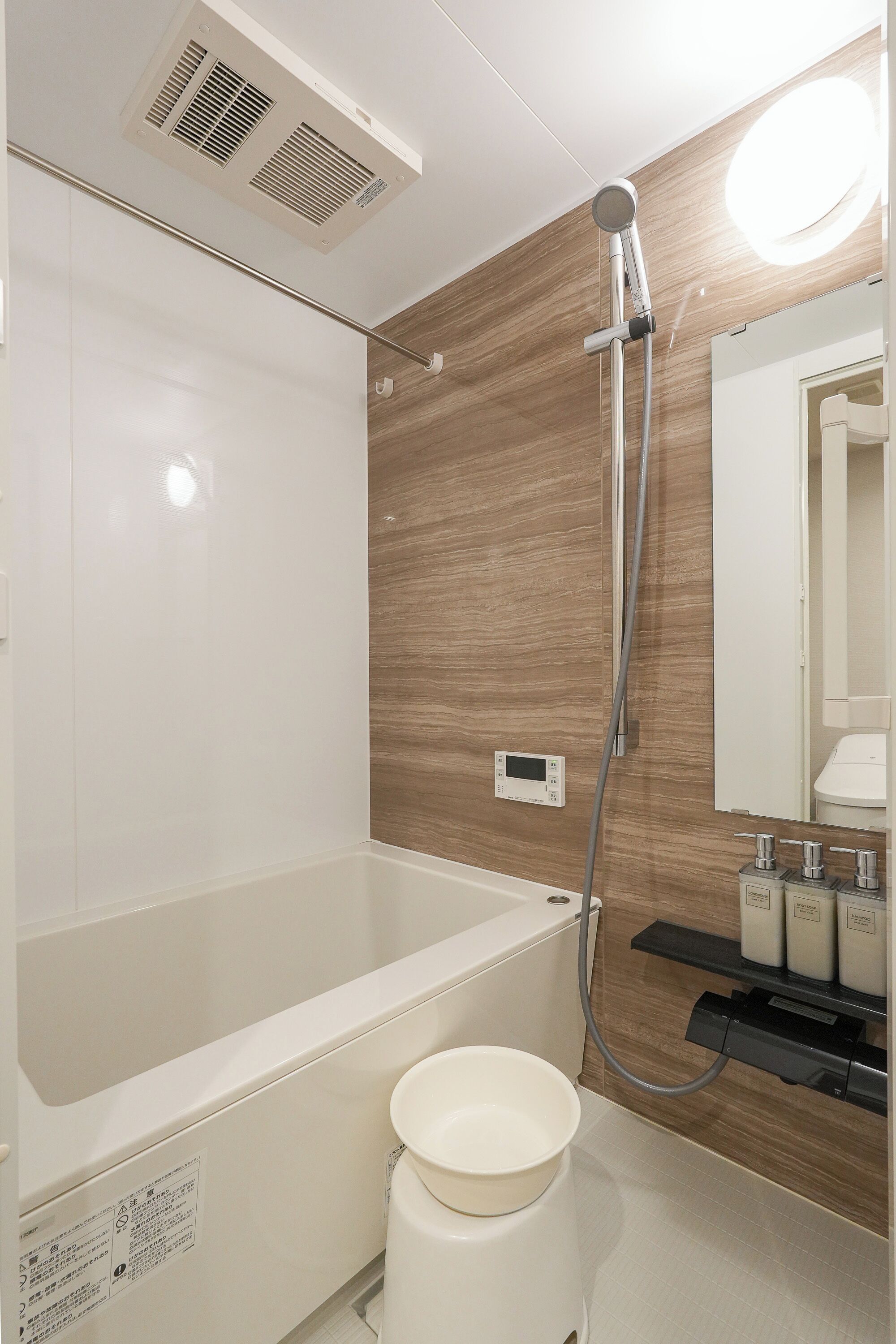 A modern bathroom with a bathtub, a shower, a toilet, and a mirror.