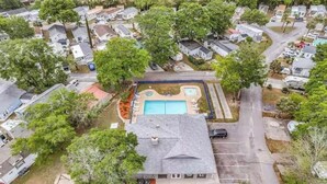 Vista aérea de un barrio residencial con casas, piscina y entrada de vehículos.
