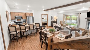 Una cucina moderna con zona pranzo, pavimento in legno e un'ampia finestra.