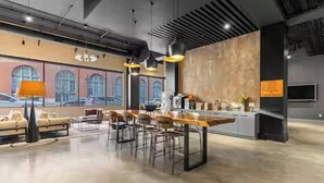 A modern kitchen with a bar area, large windows, and a seating area with sofas and chairs.