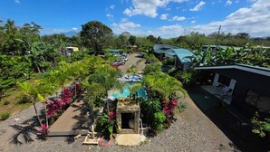 Un resort con piscina, exuberante vegetación y vistas a las montañas.
