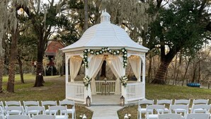 A gazebo with a white roof and white railings, surrounded by white chairs and a flower-adorned aisle. - Riverfront, HotTub, BoatRamp, Deck, Sleeps 24 (West Columbia)