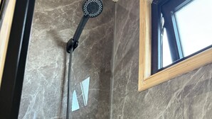 Een douche met een handdouche en een doucheslang.
