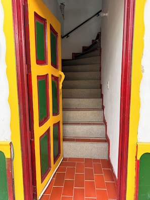 Una escalera con paredes pintadas de rojo y amarillo que conduce a una plataforma.
