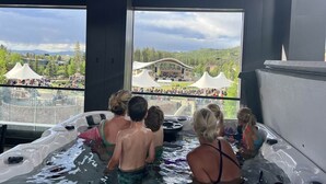 A hot tub area with a view of an outdoor event. - VIP Concert Viewing from Private Hot Tub+Walkable+5BR+Sauna+Kids Ski Gear Free (Winter Park)