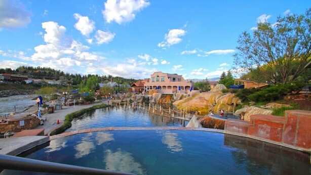A spa pool with a stone pathway and a building in the background. - Alpine Lakes Lodge, 3bd Ensuites+35 Acres+Dogs+Kids+Sleeps8+Air Conditioning! (Archuleta County)
