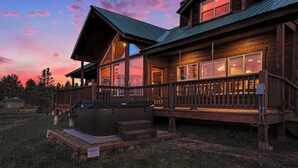 A wooden lodge with a hot tub, a covered deck, and a large window overlooking the landscape. - Alpine Lakes Lodge, 3bd Ensuites+35 Acres+Dogs+Kids+Sleeps8+Air Conditioning! (Archuleta County)
