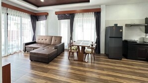A modern living room with a sectional sofa, dining table with chairs, and a kitchen area with a refrigerator. - The Star Aonang Private Pool Villa -  Aonang Krabi with 2 bedrooms (Mueang Krabi)