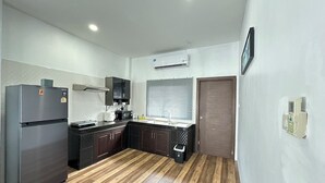 A compact kitchen with a refrigerator, microwave, and stove, a wooden floor, and a window with blinds. - The Star Aonang Private Pool Villa -  Aonang Krabi with 2 bedrooms (Mueang Krabi)