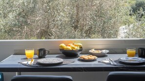 Ein Frühstückstisch mit Obstschale, zwei Orangensaftgläsern und einer Kaffeetasse.
