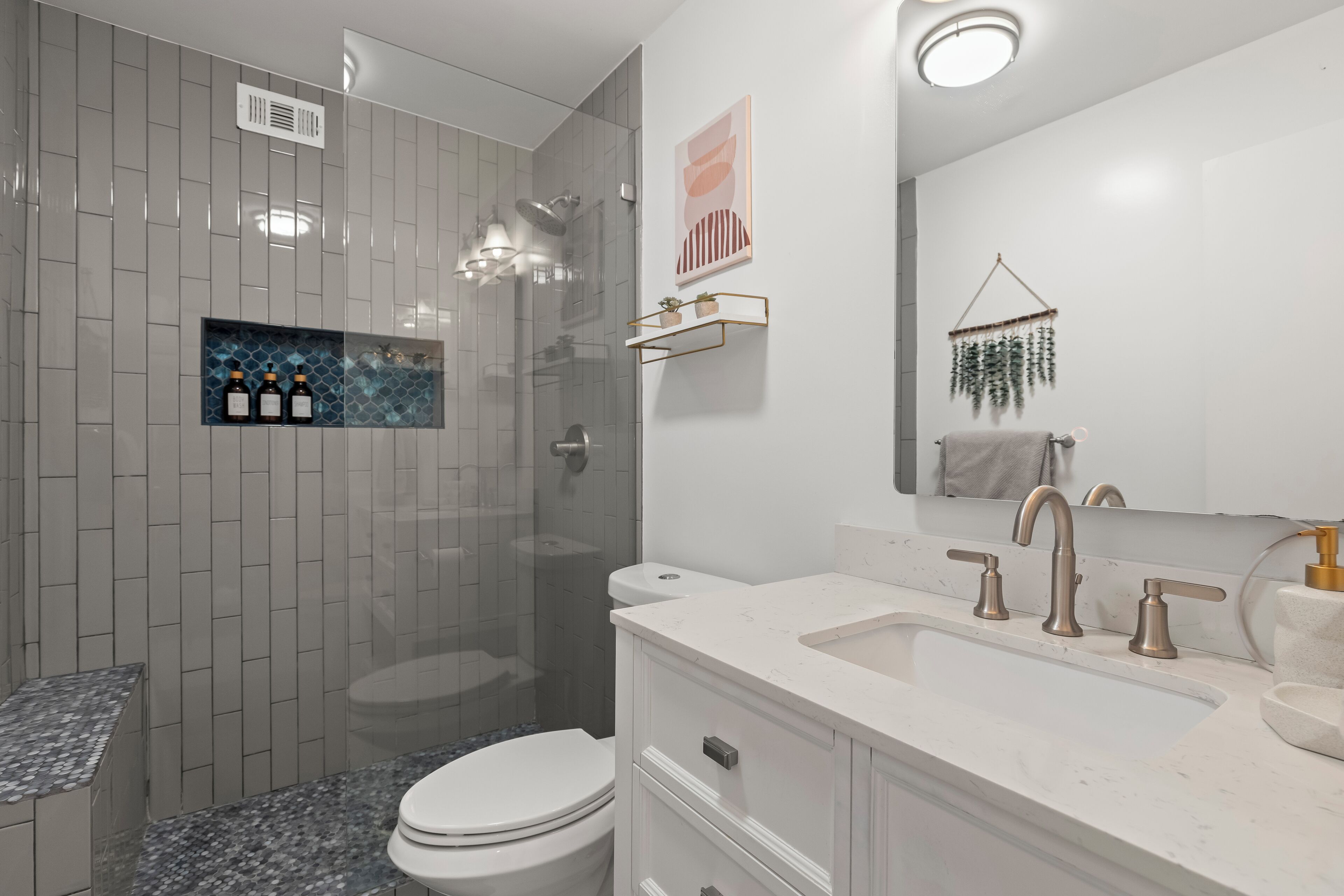 A modern bathroom with a shower, toilet, and sink.