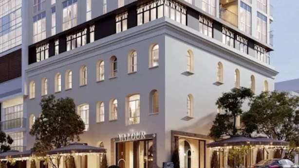 Um hotel com vários andares, varandas, restaurante no térreo e uma placa visível com a inscrição 'VALOUR'.