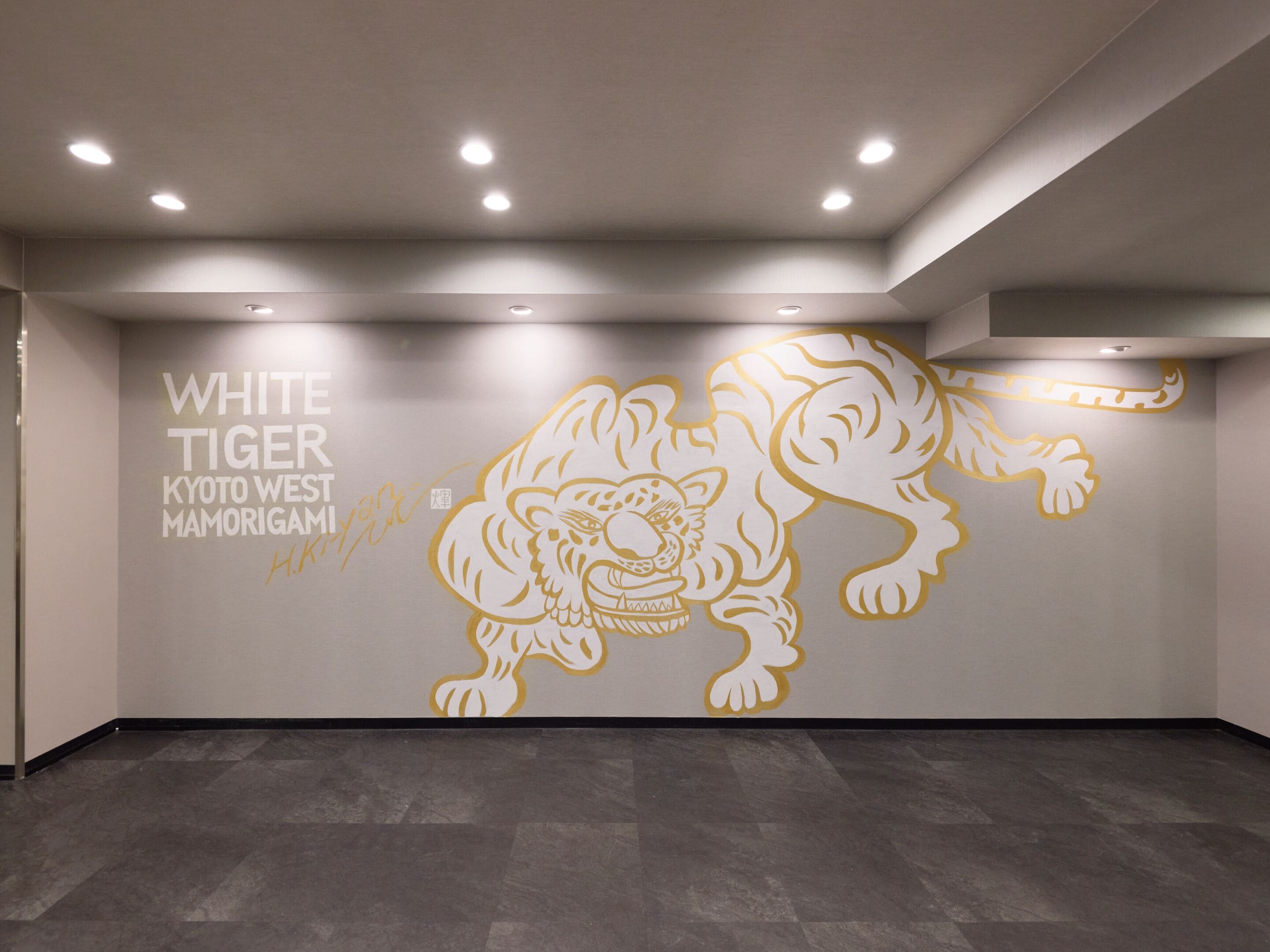 En vägg med en målning av en vit tiger och texten: ”WHITE TIGER KYOTO WEST MAMORIGAMI”.