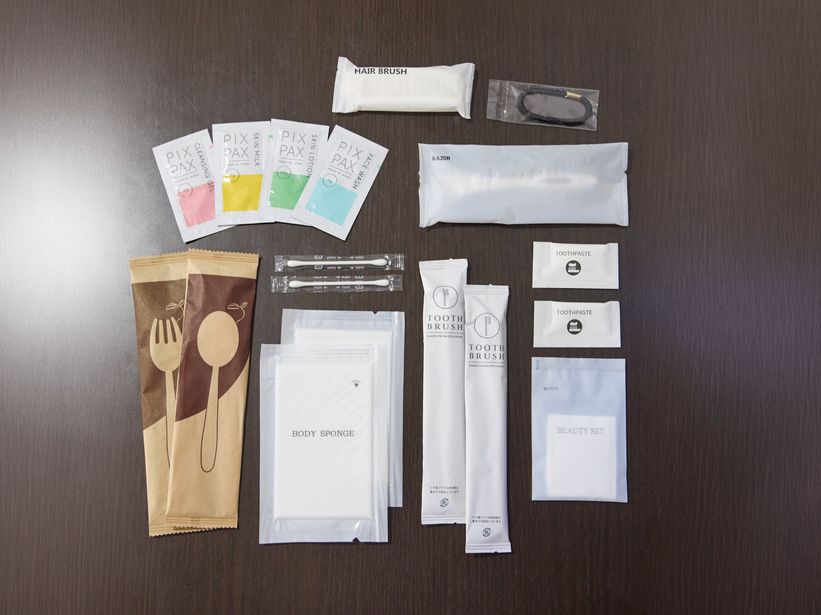A variety of personal care items laid out on a wooden surface.