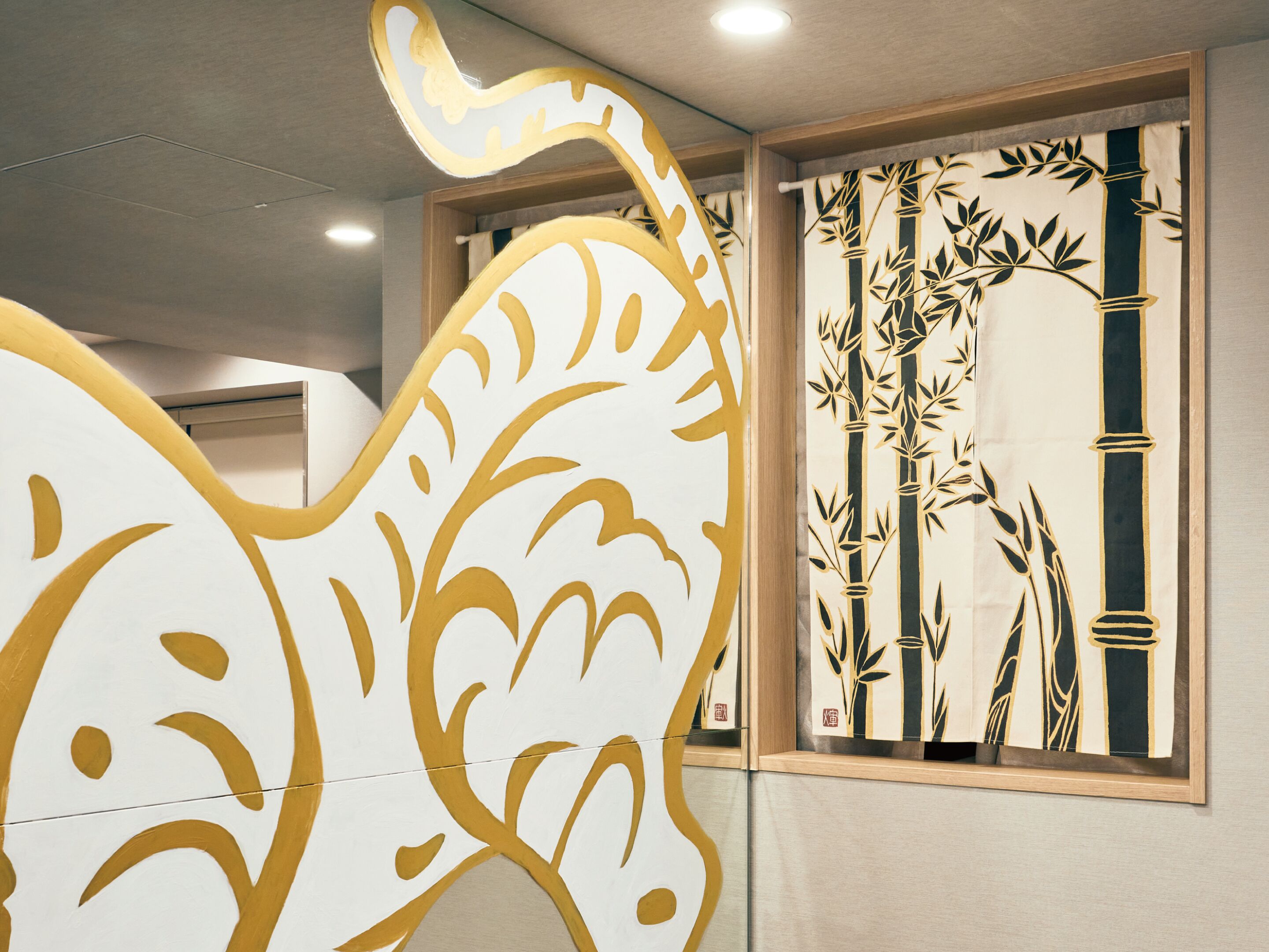 A room with a decorative wall panel featuring a stylized leaf design and a bamboo pattern.