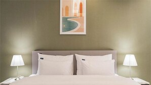 A hotel room with a bed, two bedside lamps, a nightstand, and a framed picture on the wall. - Page 9 Hotel (Seoul)