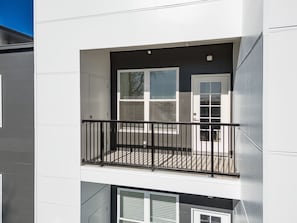 Een meerlaags gebouw met een balkon op de tweede verdieping.