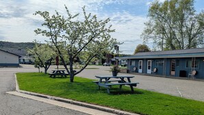 Un motel situé au bord de la route, doté de tables de pique-nique, d’un parking et d’une zone herbeuse.