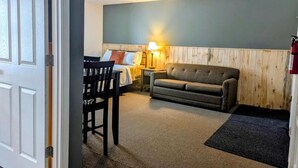 Une pièce comprenant un lit, un canapé, une table et une lampe.