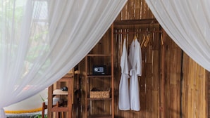 A wooden room with a shelf, a radio, a basket, and a pair of shoes. - LeLangit Eco Cabin (Sidemen)