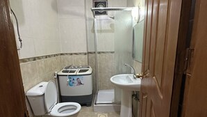Une salle de bain équipée de toilettes, d’un bidet et d’un lavabo.