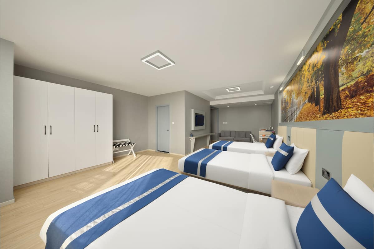 A hotel room with two beds, a wardrobe, a desk, a chair, a TV, and a painting of a forest.