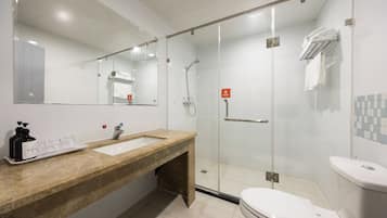 Un baño moderno con ducha de vidrio, lavamanos con encimera de mármol y retrete.