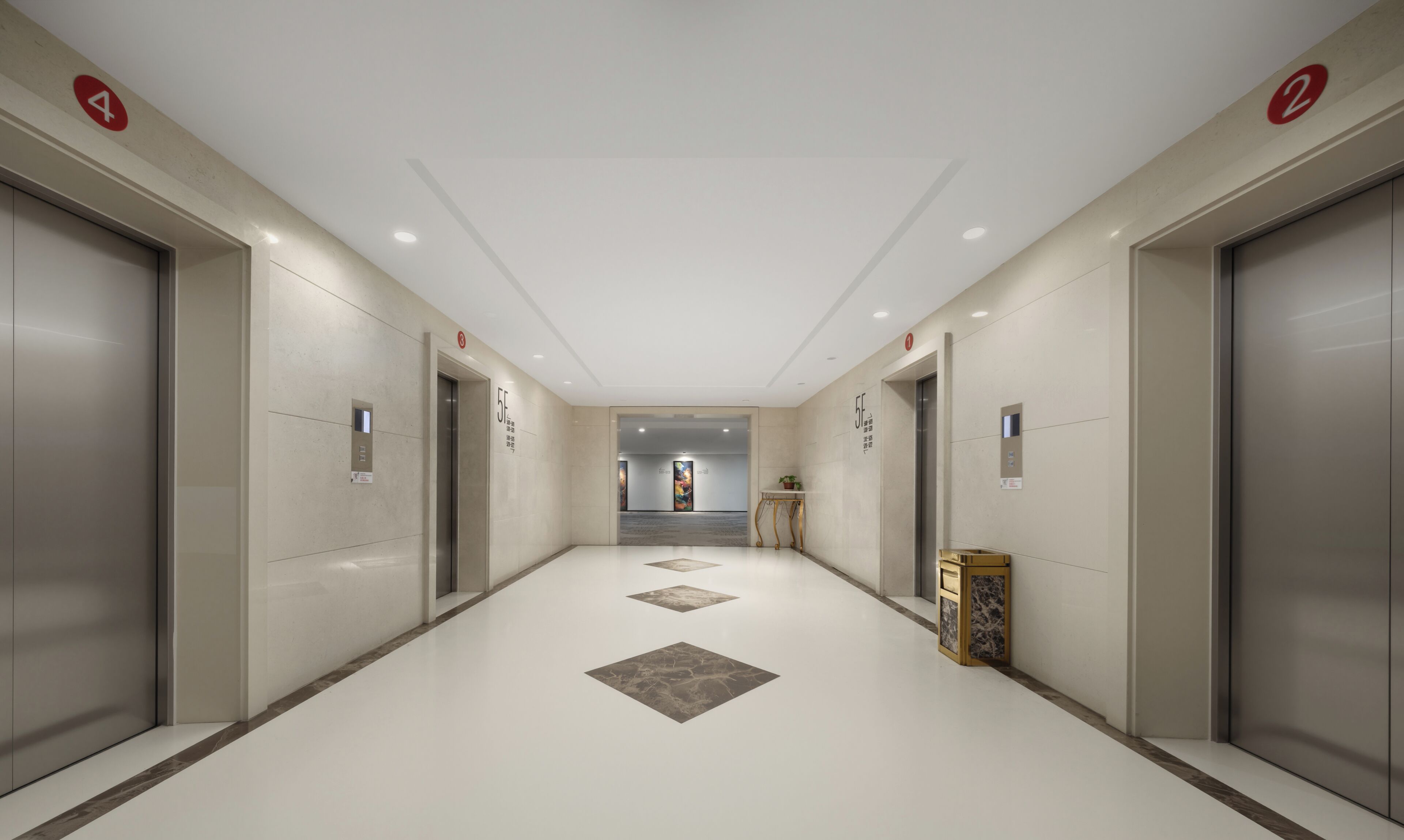 A modern hallway with elevators, a small table with a plant, and a decorative box.