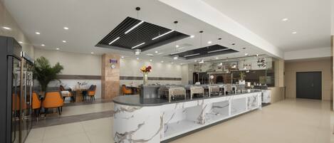 A modern hotel lobby with a marble reception desk, seating area, and a large window.