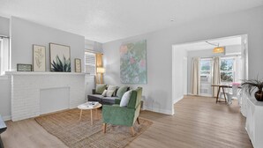 Uma sala de estar moderna com lareira, um sofá, uma mesa de centro e um quadro grande.
