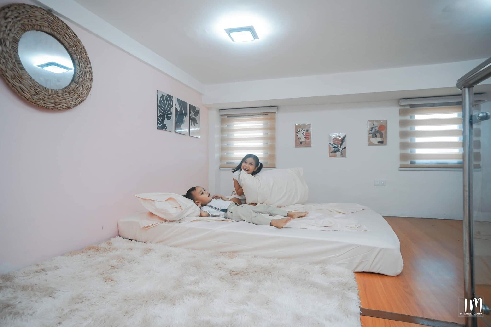 Une chambre à coucher avec un lit, un tapis moelleux et un miroir au mur.