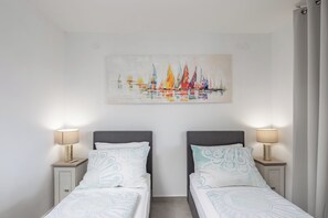 A hotel room with two beds, a painting of sailboats, and bedside lamps. - Susi's Holiday Home, Pula, Croatia (Pula)