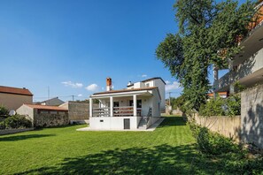 A small white house with a balcony, a chimney, and a well-maintained lawn. - Susi's Holiday Home, Pula, Croatia (Pula)