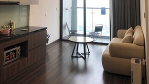 Ein modernes Wohnzimmer mit einer Couch, einem Esstisch und einer Küchenzeile.