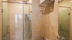 A modern bathroom with a glass-enclosed shower, a white toilet, and a large white sink. - X-Stay Bloom (Hai Phong)