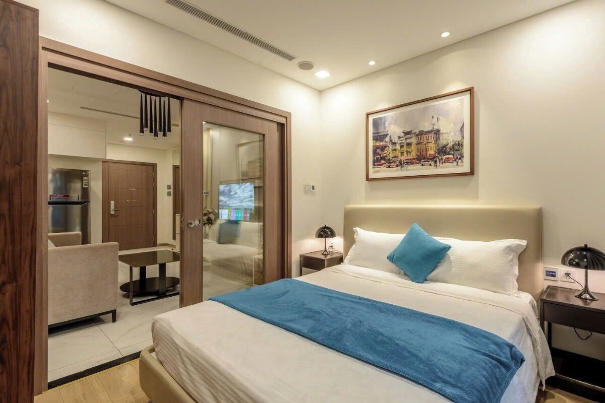 Une chambre d’hôtel avec un lit, un bureau, une chaise, une armoire et un tableau au mur.