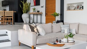 A modern living room with a sofa, coffee table, and decorative items. - Villa Bali Escape– Private Ricefield Retreat, Steps from the Canggu Action (Canggu)